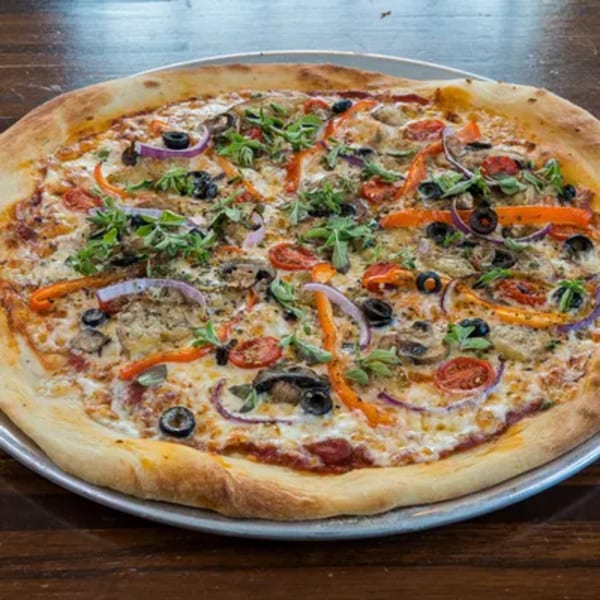 Blue Eye Bistro's vegetarian pizza, topped with olives, peppers, onions, mushrooms, and fresh herbs.