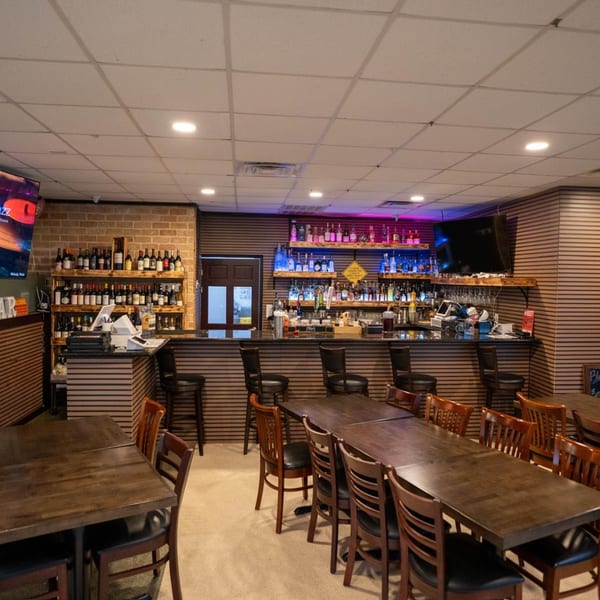 Interior of Blue Eye Bistro, showing a well-stocked bar with colorful lighting and dining tables.